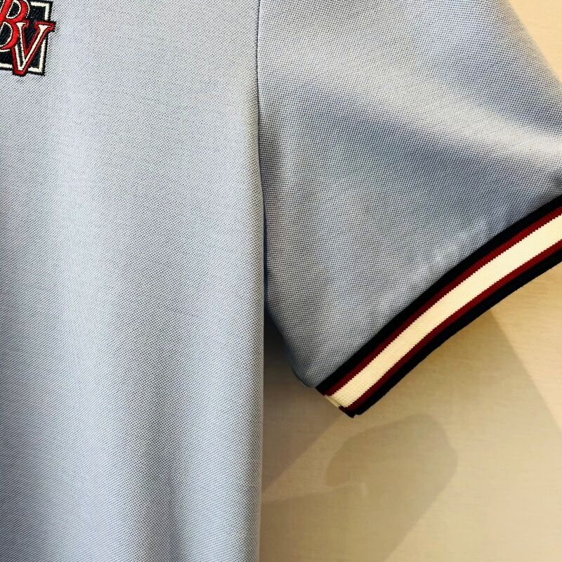 پیراهن پولو مردانه آبی روشن با یقه کنتراست و لوگوی گلدوزی شده، سبک نیمه‌رسمی، پیراهن‌های پولو مردانه از جنس پیکه